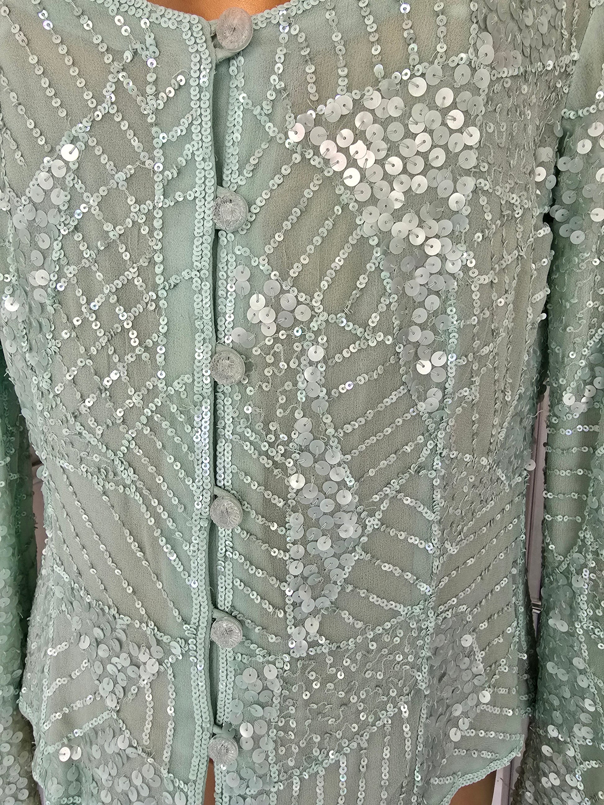 Green fabric with sequin patterns and buttons 