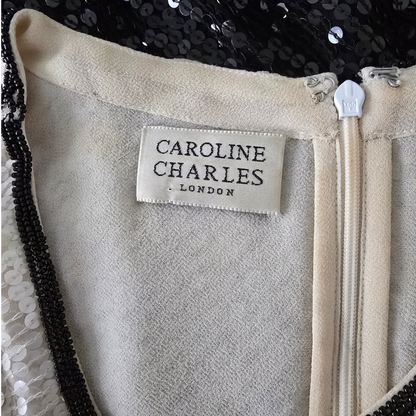 Close-up of a label on a garment with 'Caroline Charles London' branding.