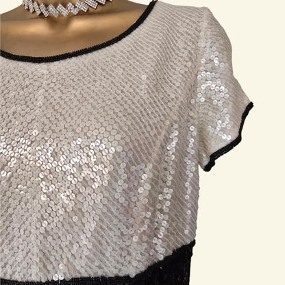 Sequined top with black trim on a white background