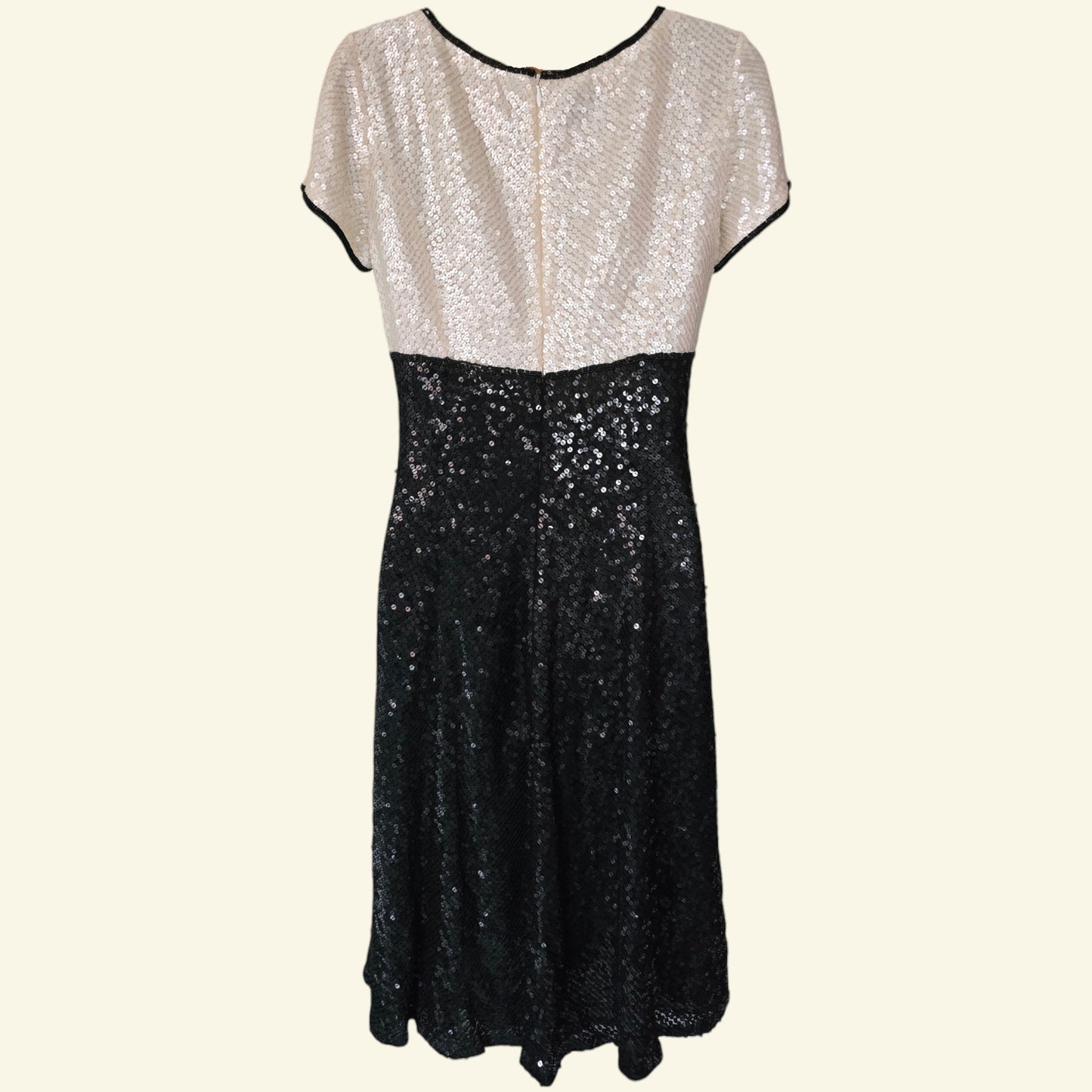 Two-tone sequin dress with white top and black bottom on a white background