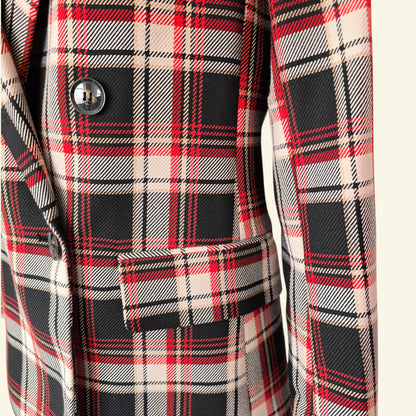 Close-up of a plaid coat with red, black, and beige pattern.