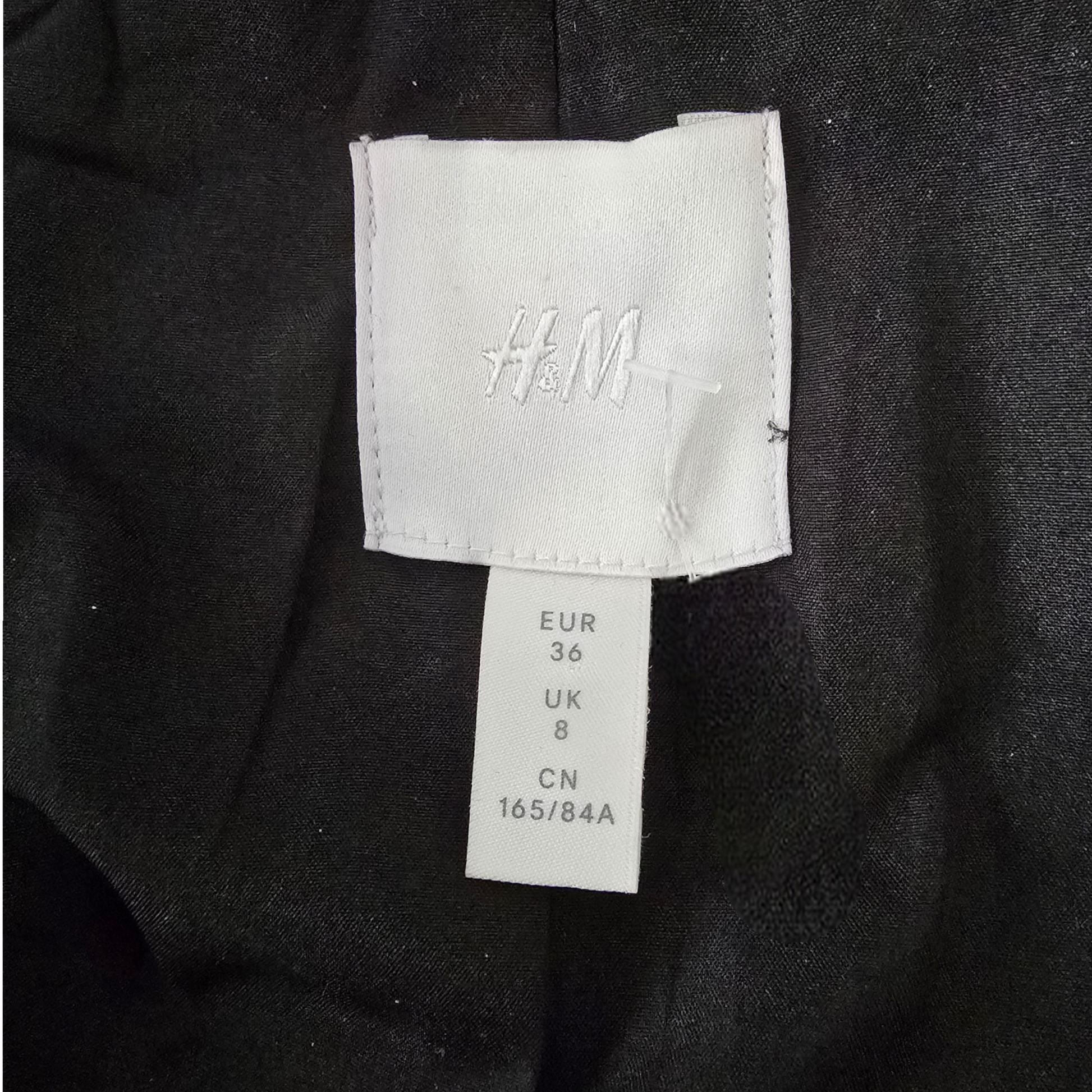 Close-up of an H&M label on a dark fabric background