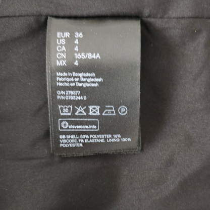 Clothing label with size and care instructions on a dark fabric background