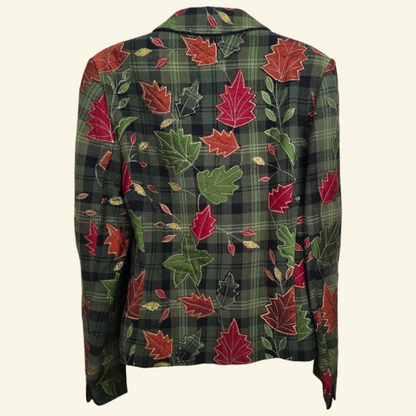 A long-sleeve plaid blazer jacket featuring an all-over autumn leaf pattern in red, green, and gold on a dark green plaid background, shown against a light cream background.