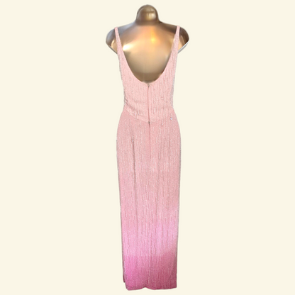 A sleeveless pink maxi low back dress  displayed on a metallic gold mannequin against a light cream background.