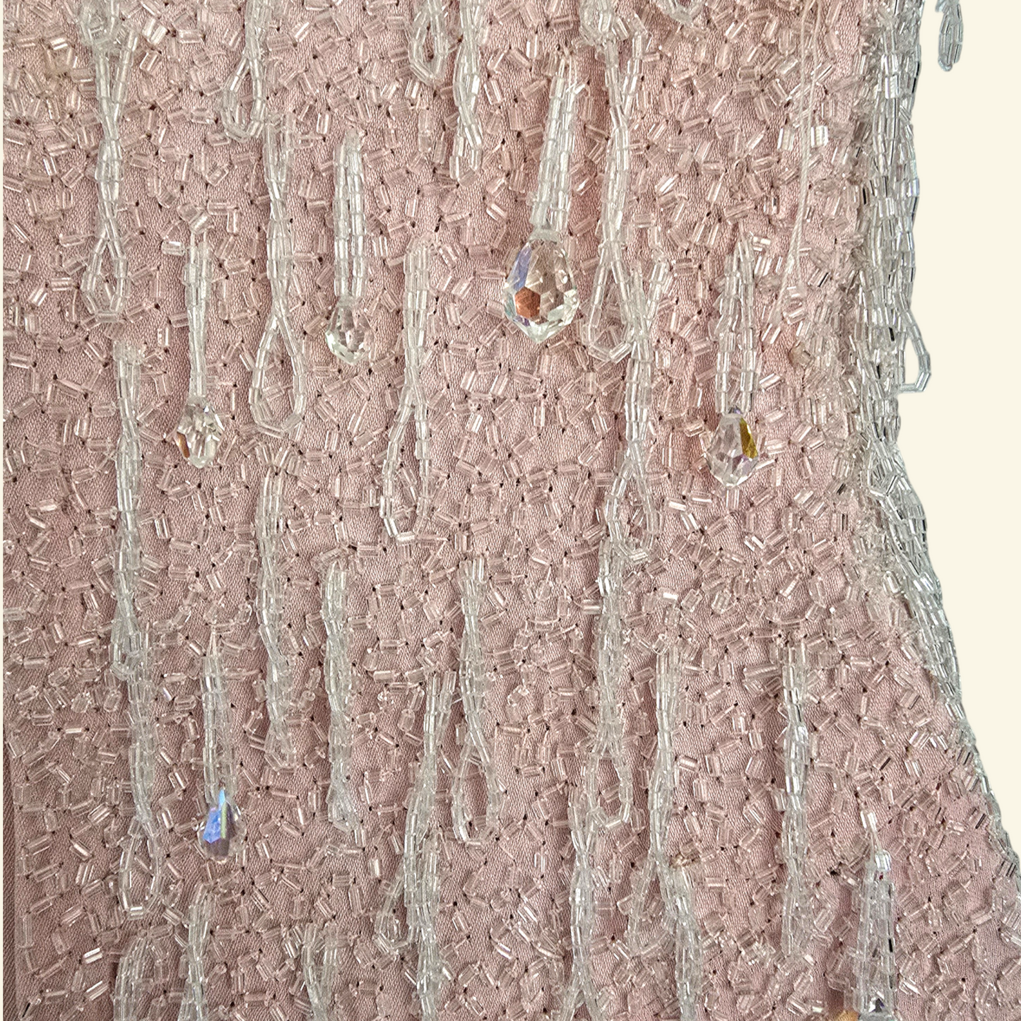 Close up of hand sewn bead detail on beige background