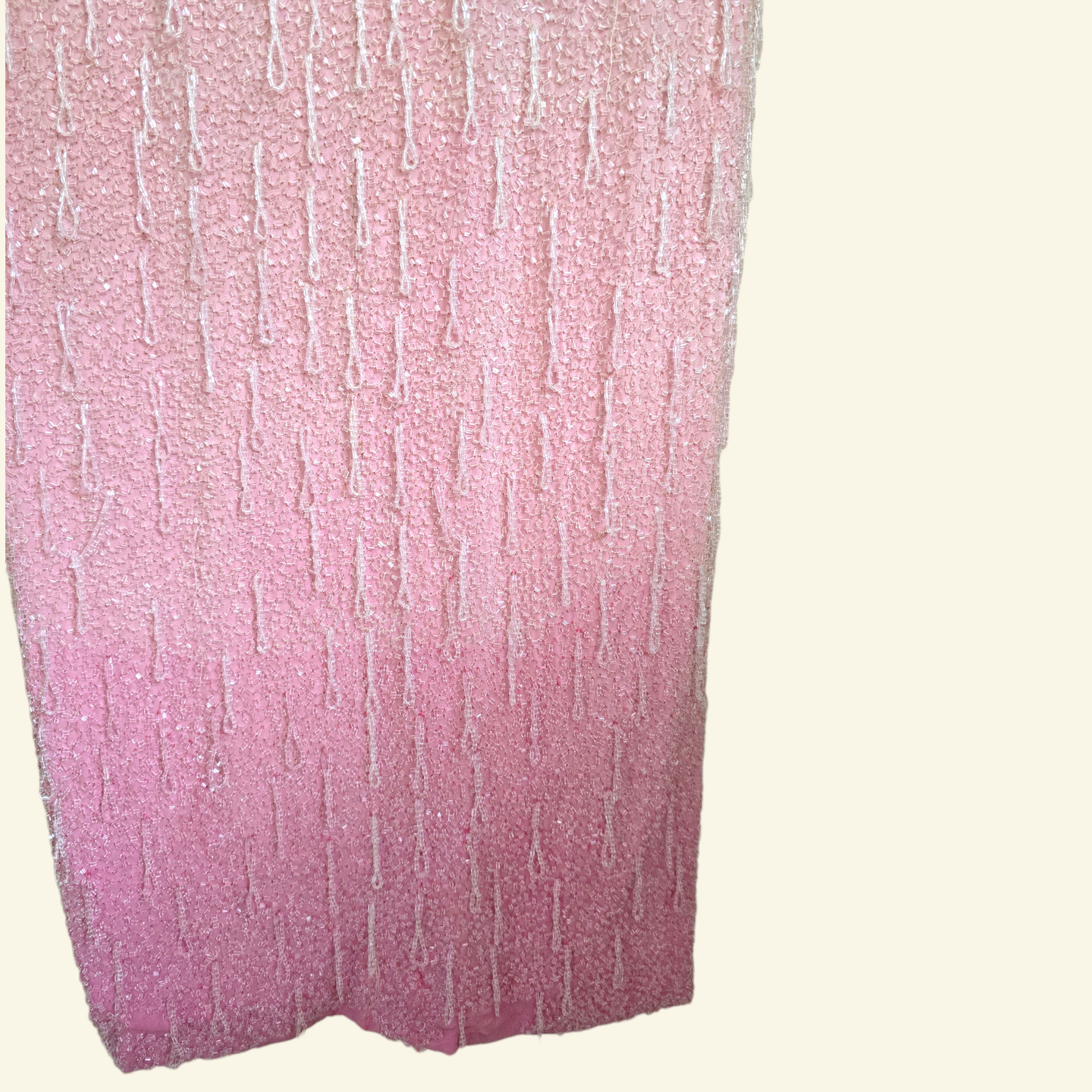 Close up of two town pink detail on bottom of pink dress on beige background