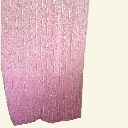 Close up of two town pink detail on bottom of pink dress on beige background