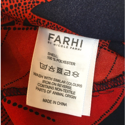 Fabric label with 'FARHI' branding on a red and black patterned fabric background
