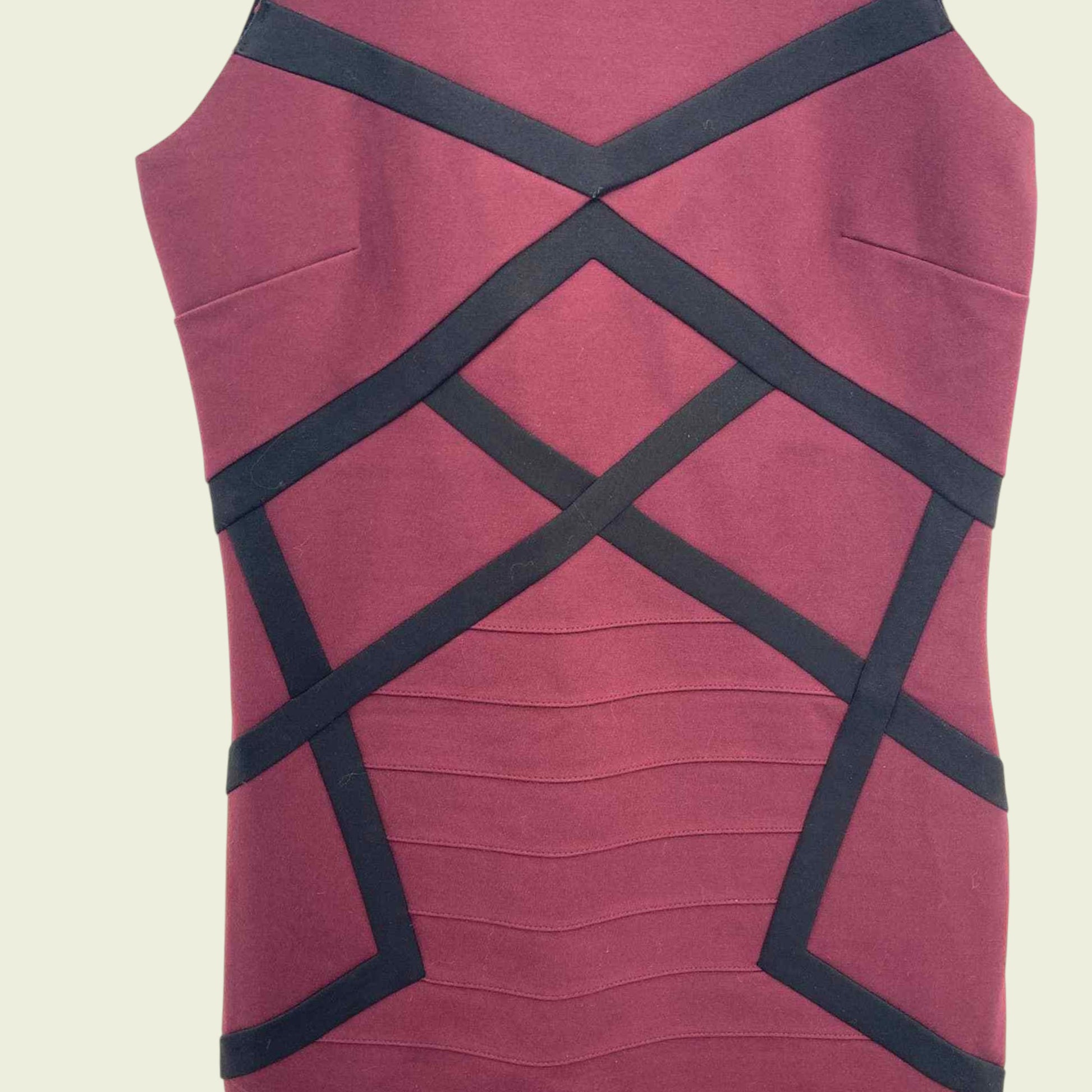 Maroon dress with black criss-cross straps on a beige background