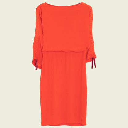 Red dress with ruffled sleeves on a beige background