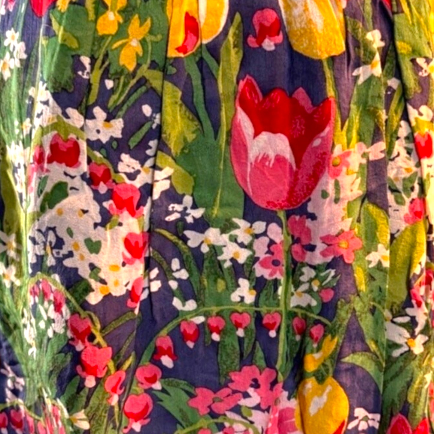 Close-up of a colorful floral pattern with tulips and other flowers on a dark background.
