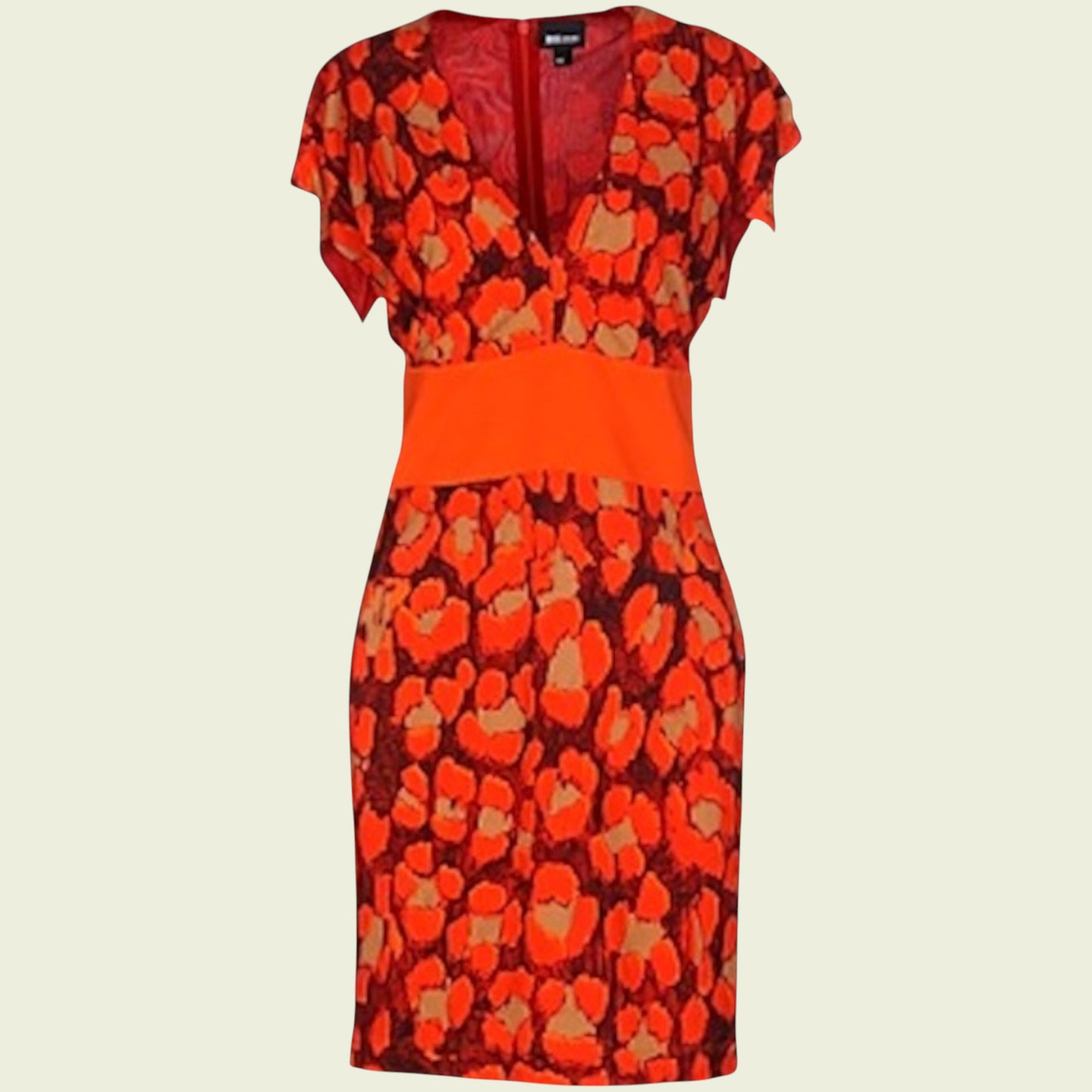 Mannequin wearing bright orange and black dress on beige background