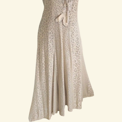 A sleeveless beige maxi dress with a textured pattern, shown against a solid cream background.