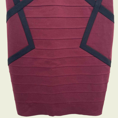 Maroon dress with black geometric accents on a beige background