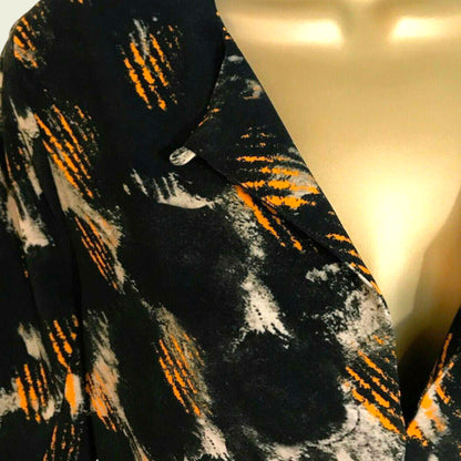 Textured fabric with black, orange, and white pattern on a neutral background