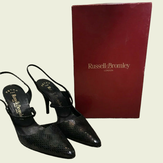 Black high-heeled shoes with a red box featuring 'Russell & Bromley' branding on a light background.