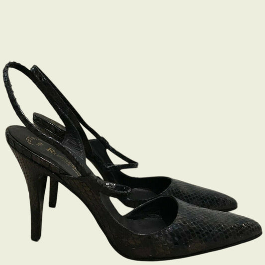 Pair of black high-heeled shoes on a beige background