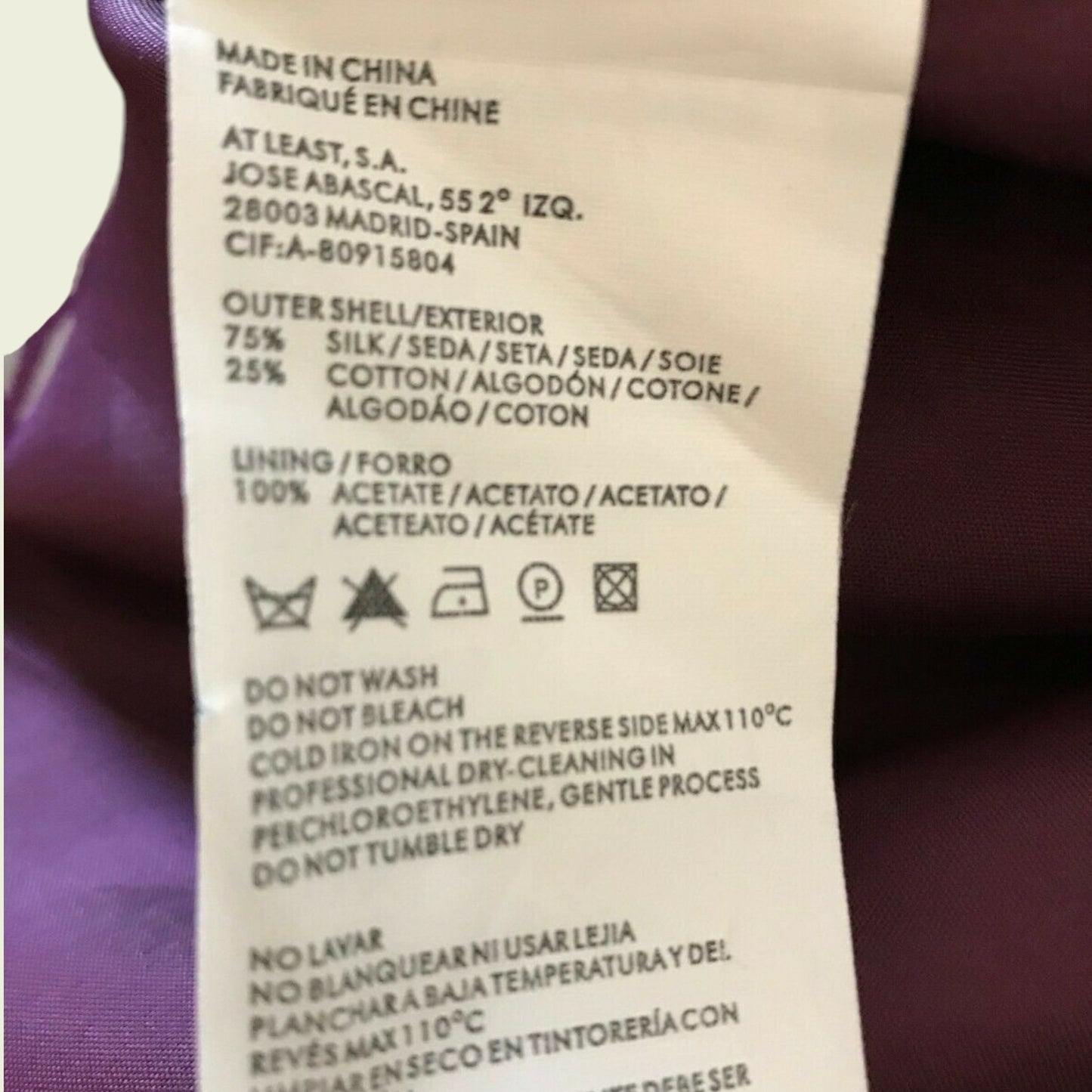 Fabric label with text and symbols on a purple fabric background