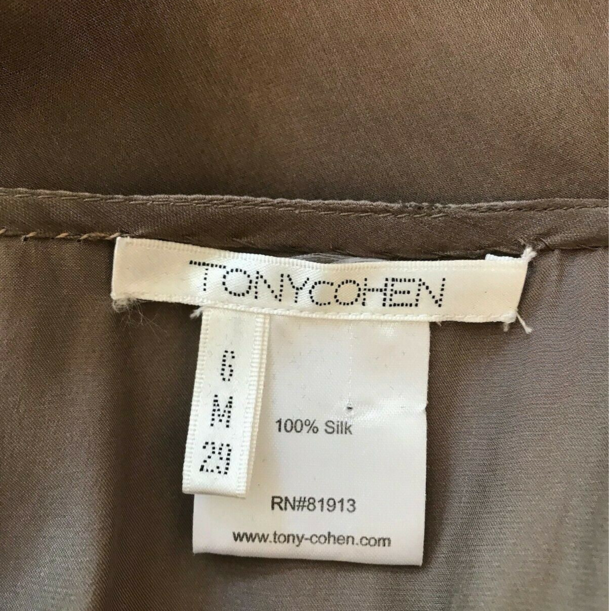 Label on a brown fabric item with 'TONYCOHEN' branding.