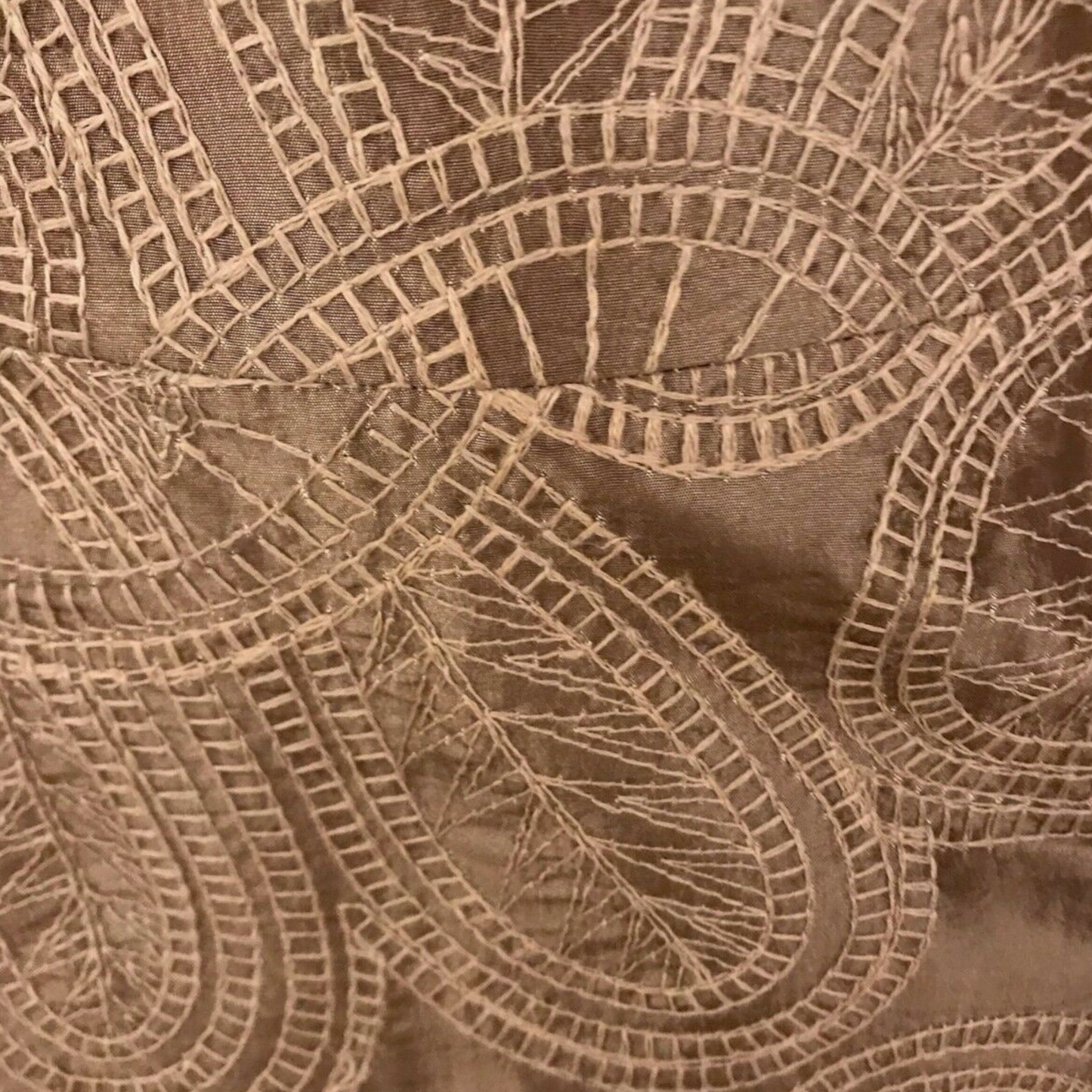 Close-up of brown fabric with intricate lace pattern