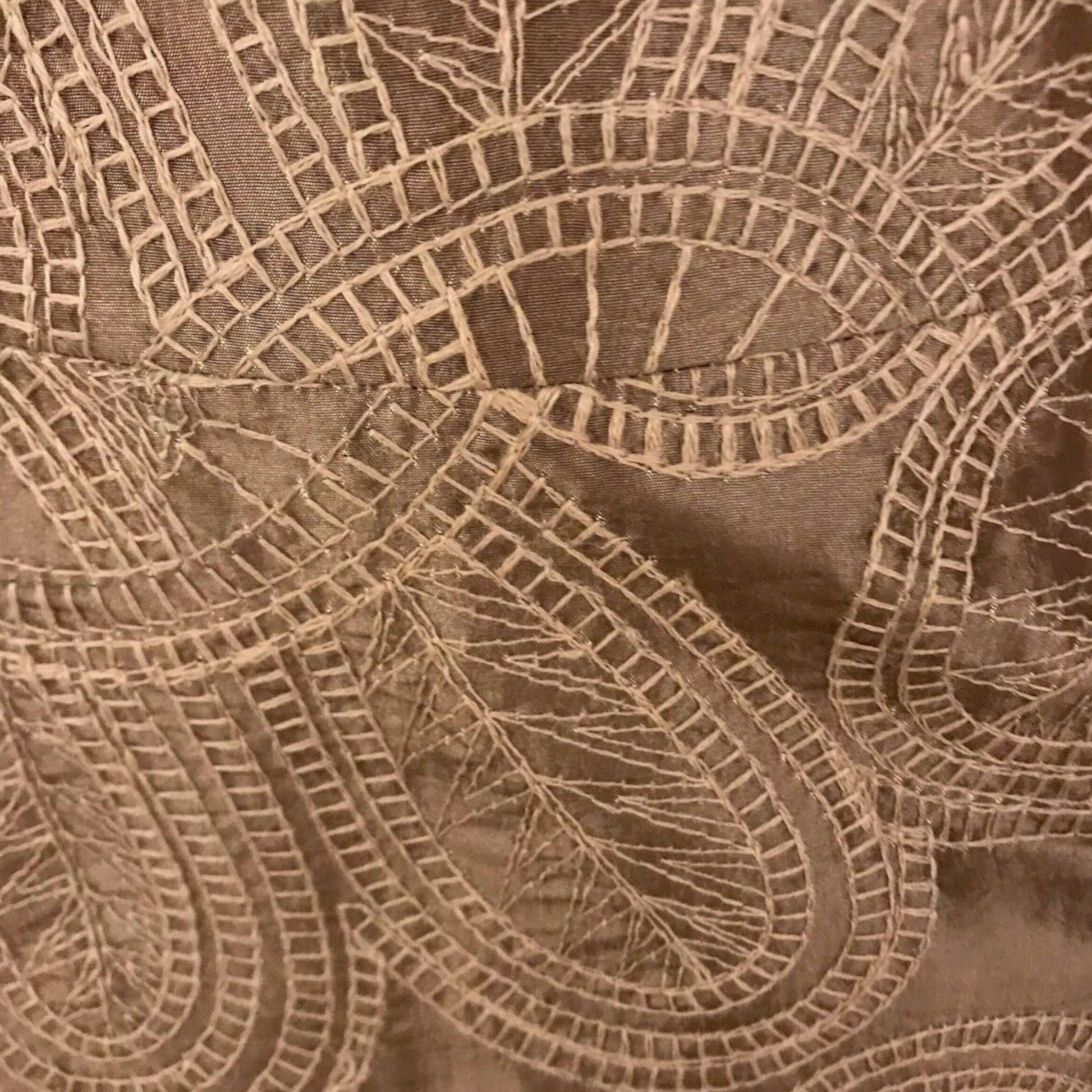 Close-up of brown fabric with intricate lace pattern