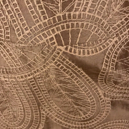 Close-up of brown fabric with intricate lace pattern