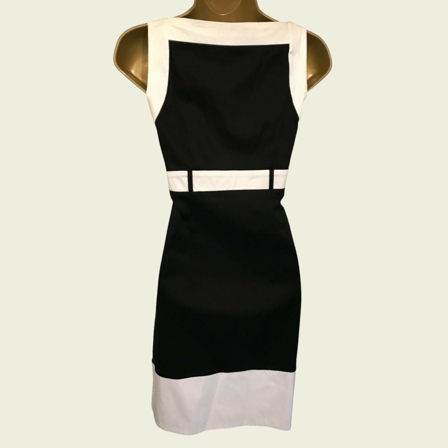 Mannequin wearing black and white dress on beige background