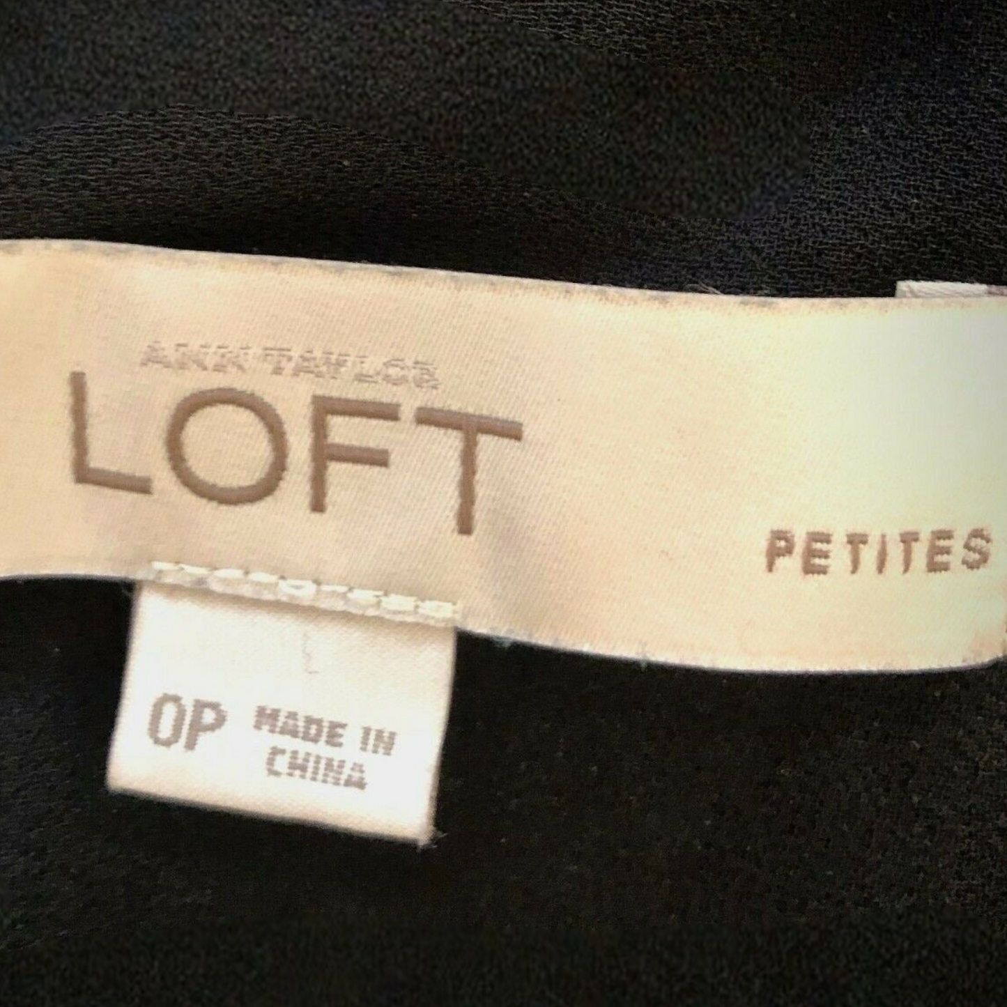 An Taylor Loft petites label on a black garment