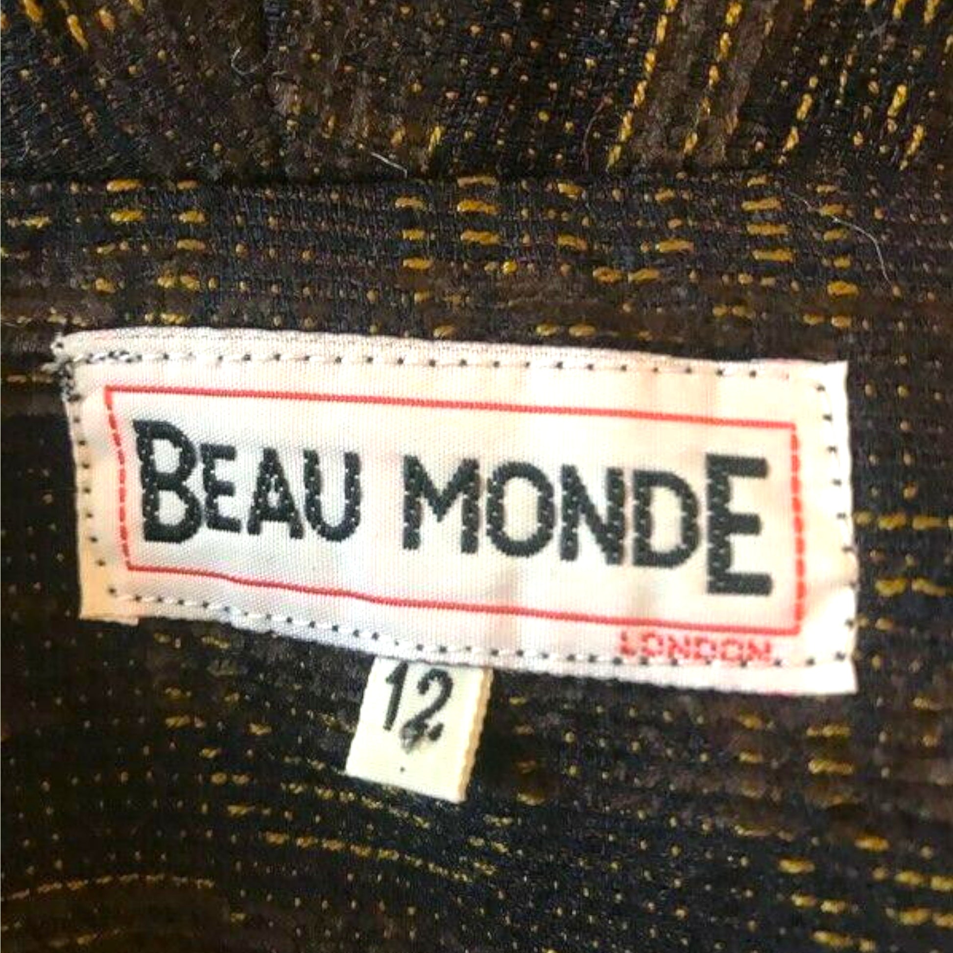 Label with 'BEAU MONDE' text on a textured fabric background