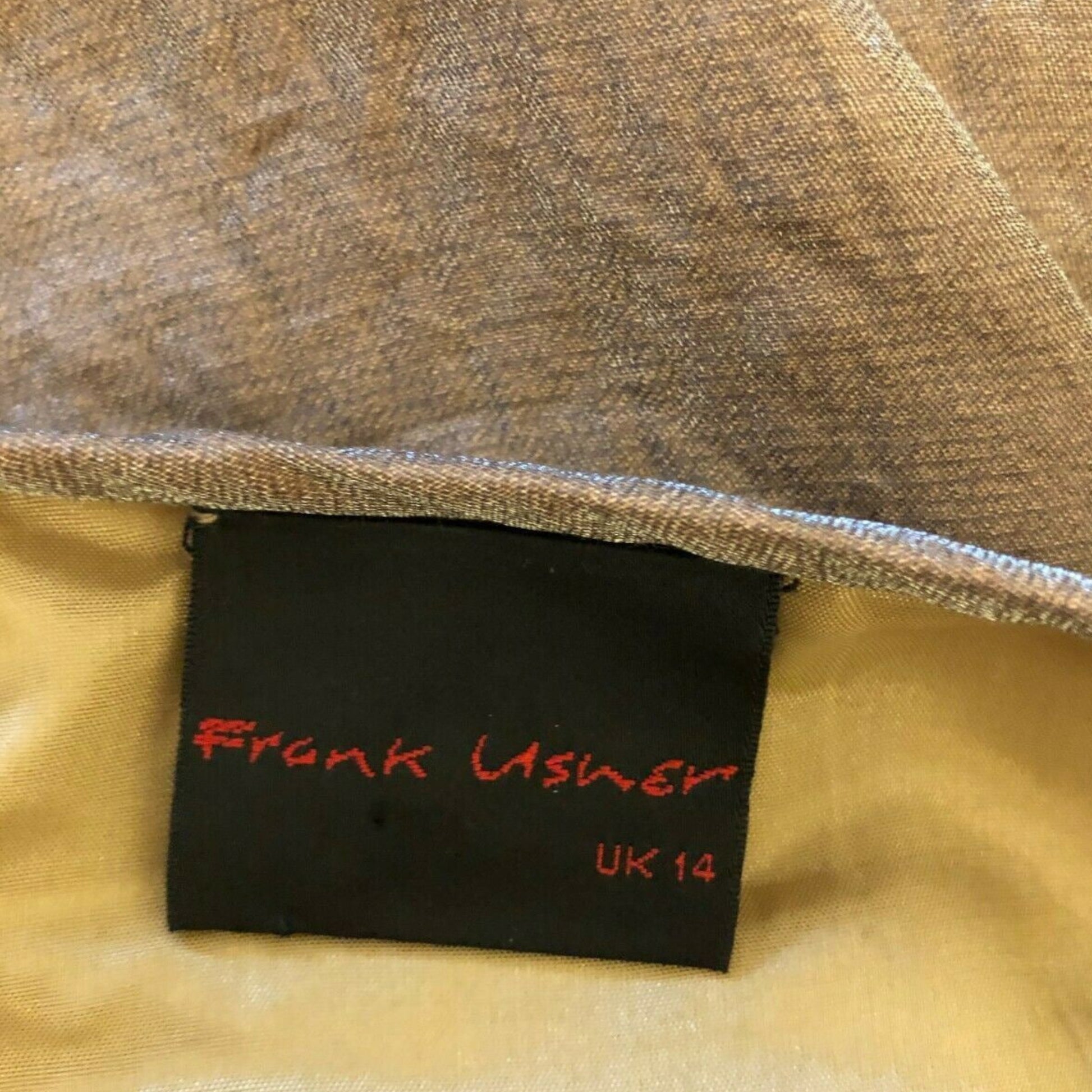 Clothing label with 'Frank Usher' text on a textured fabric background