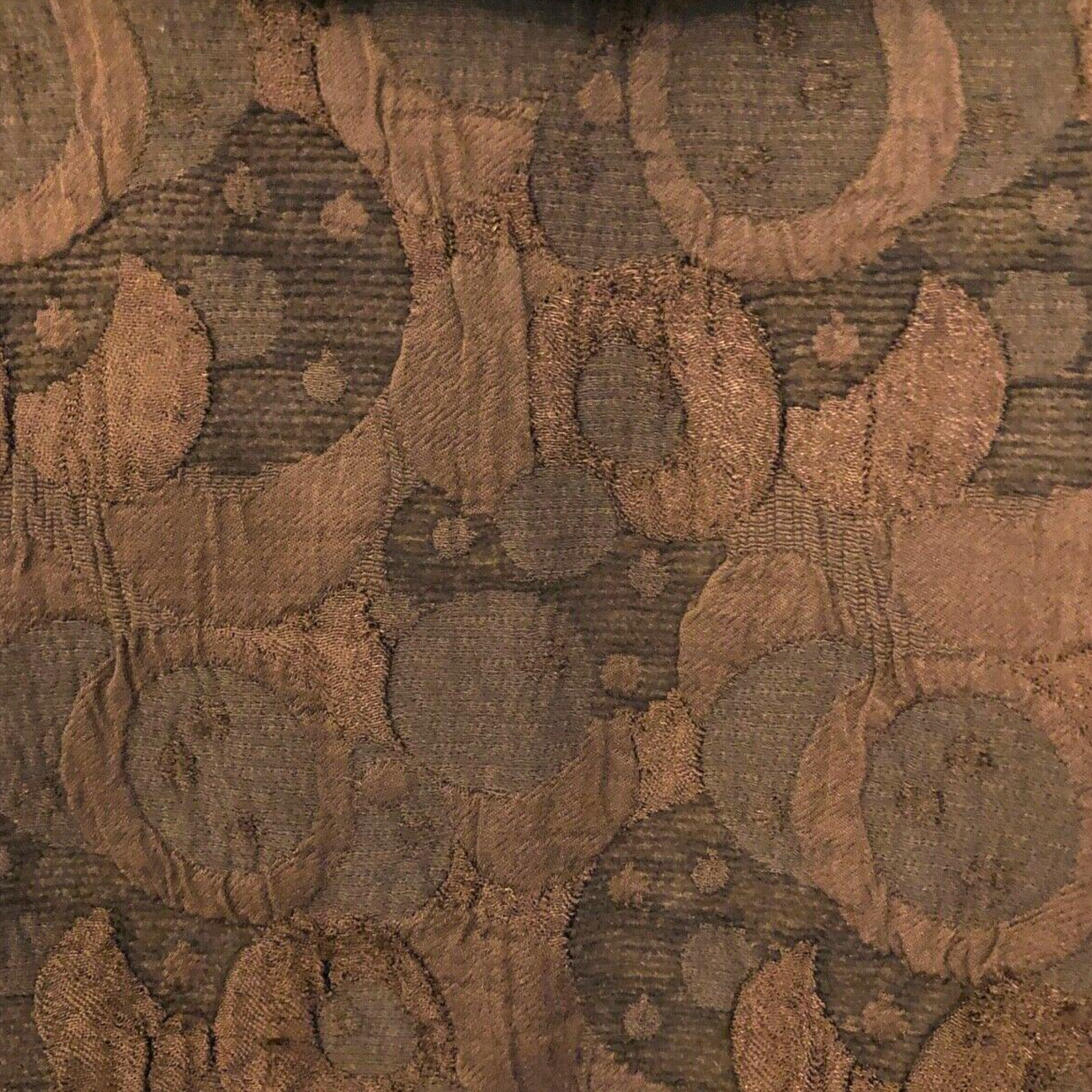 Close-up of a textured fabric with circular patterns in brown and beige tones.
