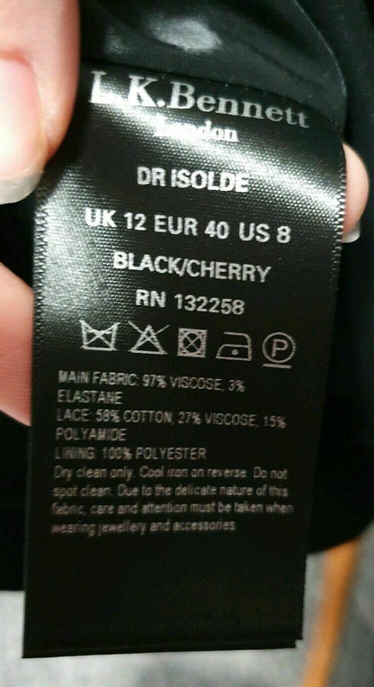 Clothing label with brand name and size information held by a hand