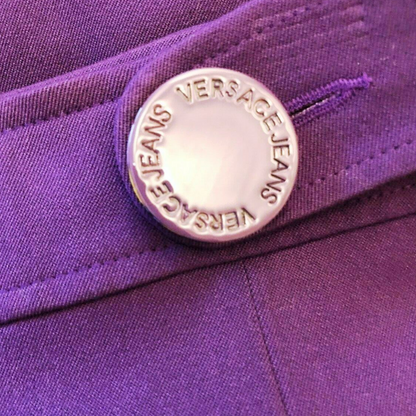 Close-up of a Versace Jeans button on a purple fabric background
