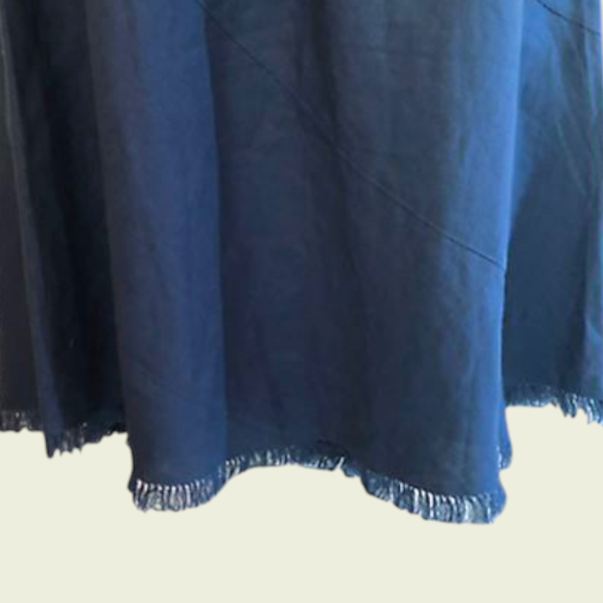 Teal fabric with frayed edge on a beige background