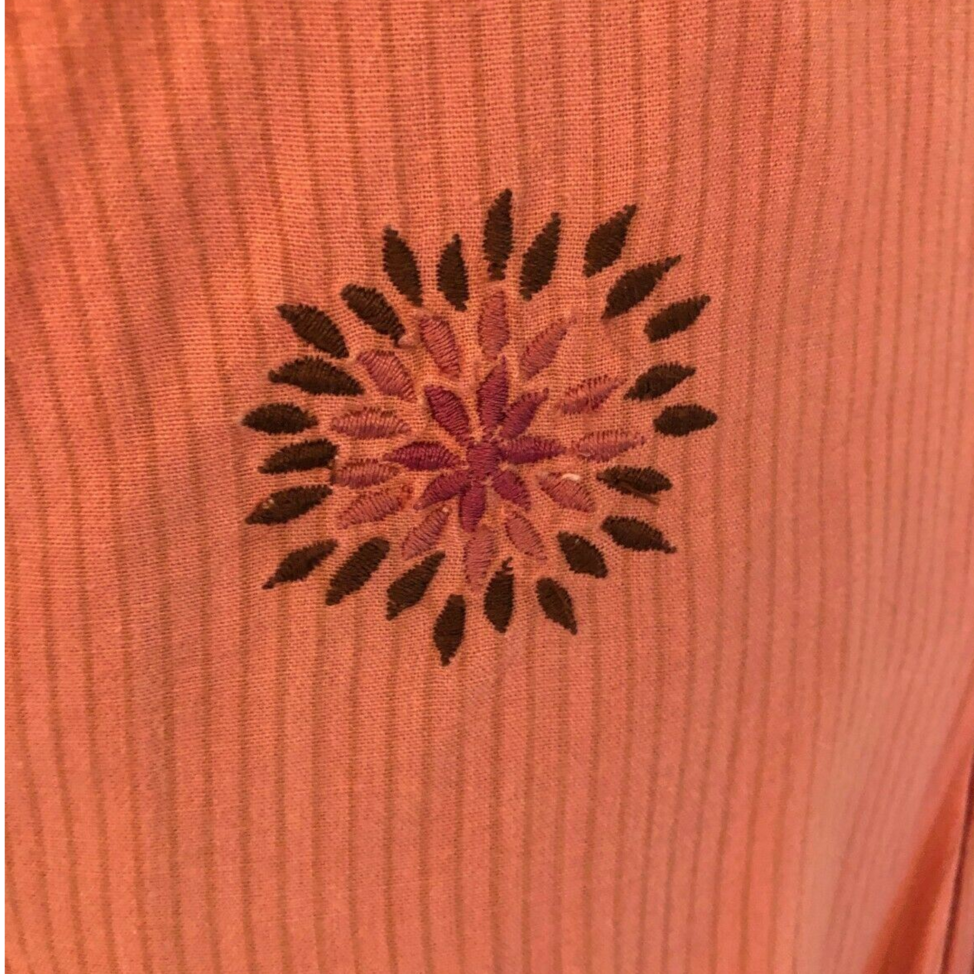 Embroidered design on a pink fabric background