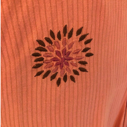 Embroidered design on a pink fabric background