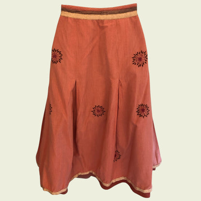 Orange skirt with black floral patterns on a beige background