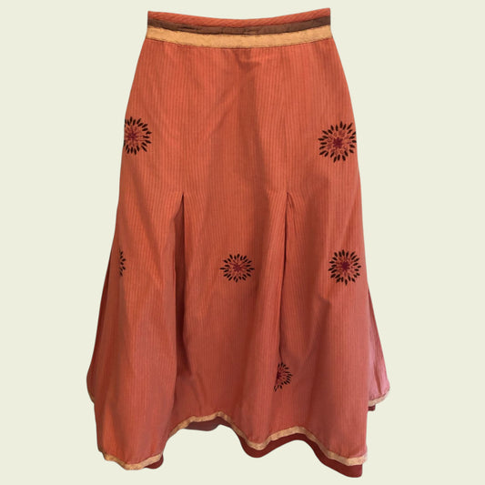 Orange skirt with black floral patterns on a beige background