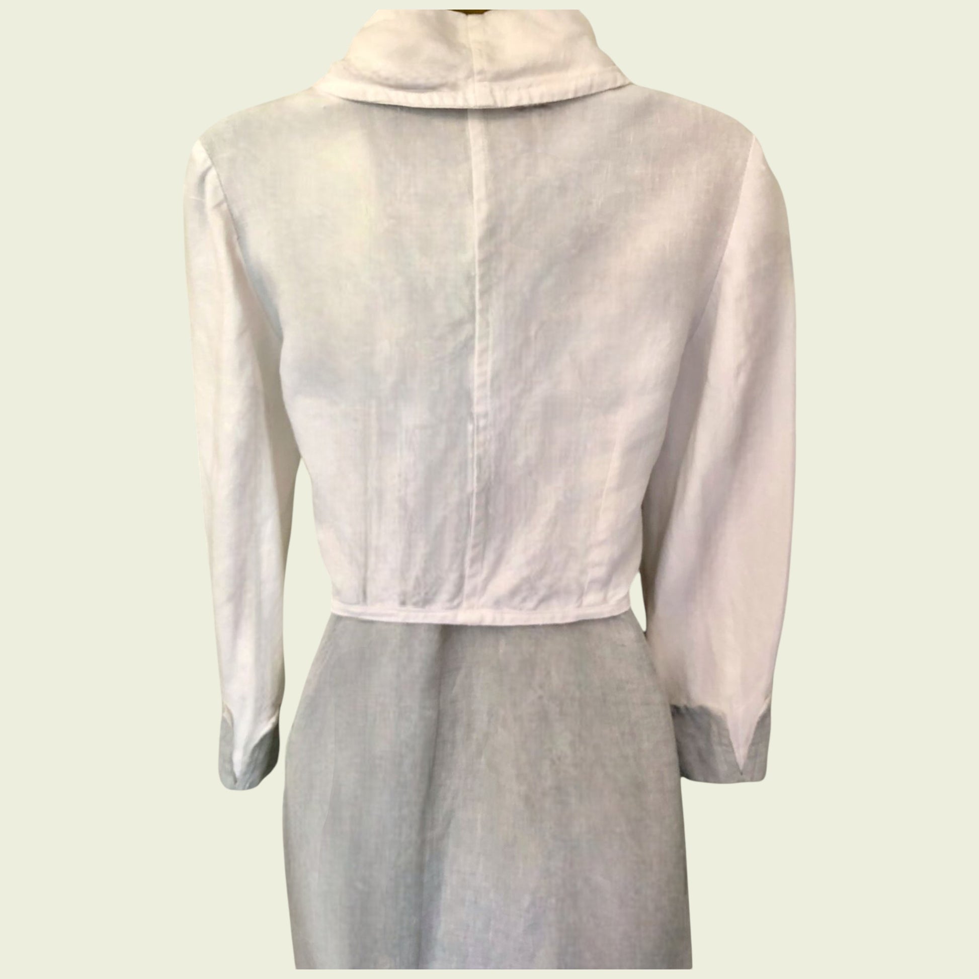 Light pink sheer jacket over a light gray dress on a white background