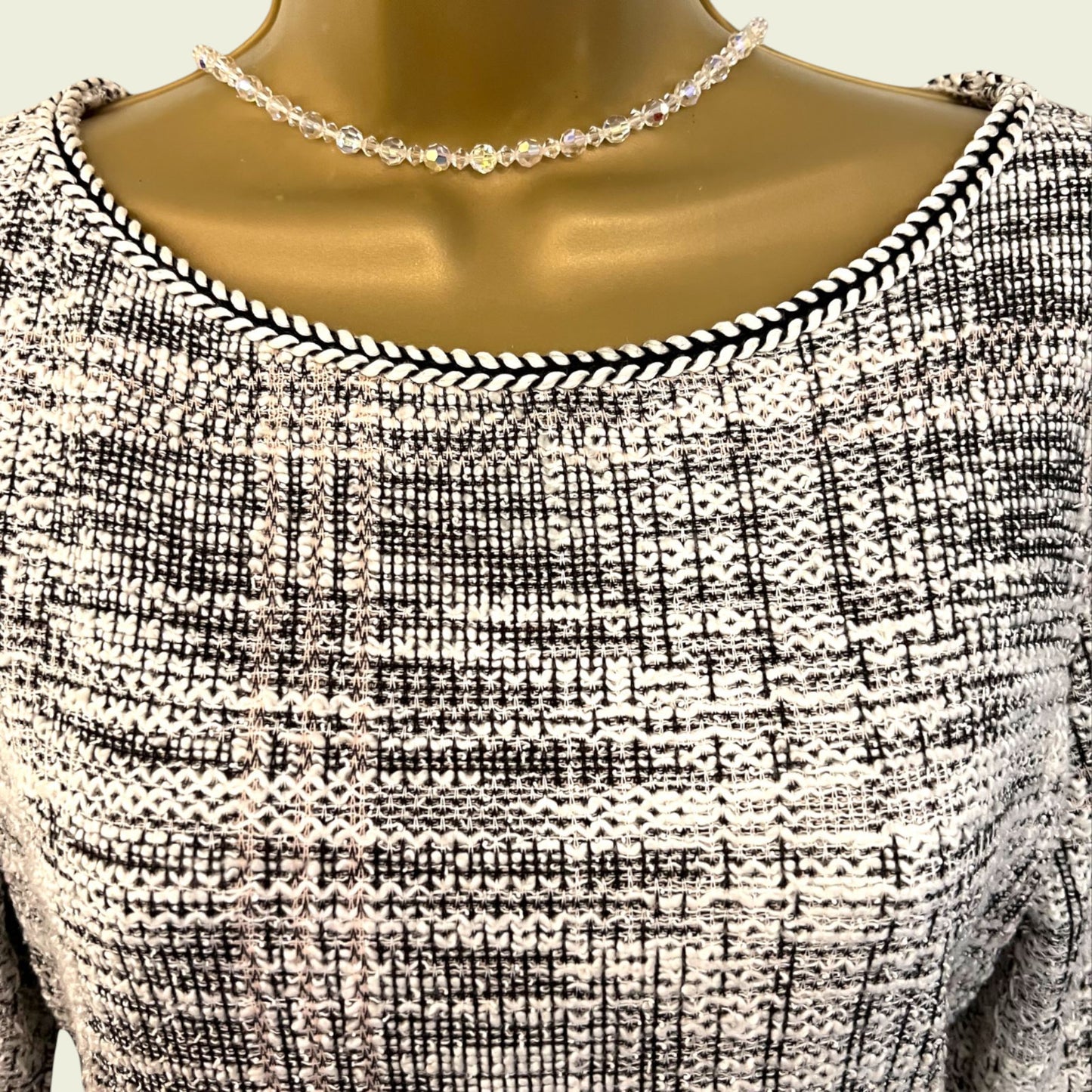 Black and white patterned dress on a mannequin with a necklace.