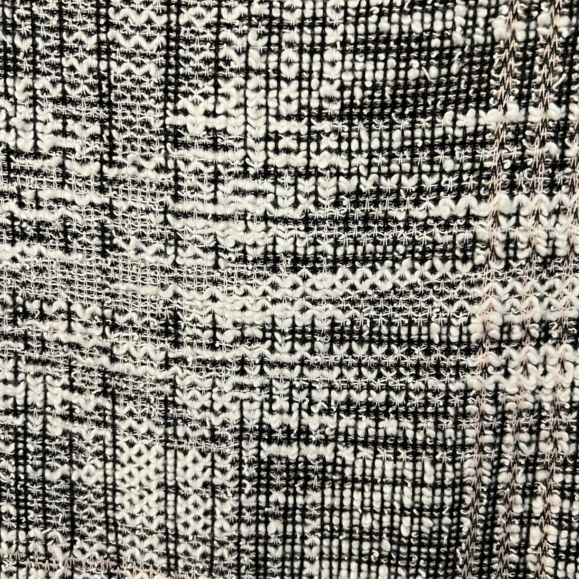 Close-up of a textured fabric with a checkered pattern in black and white.