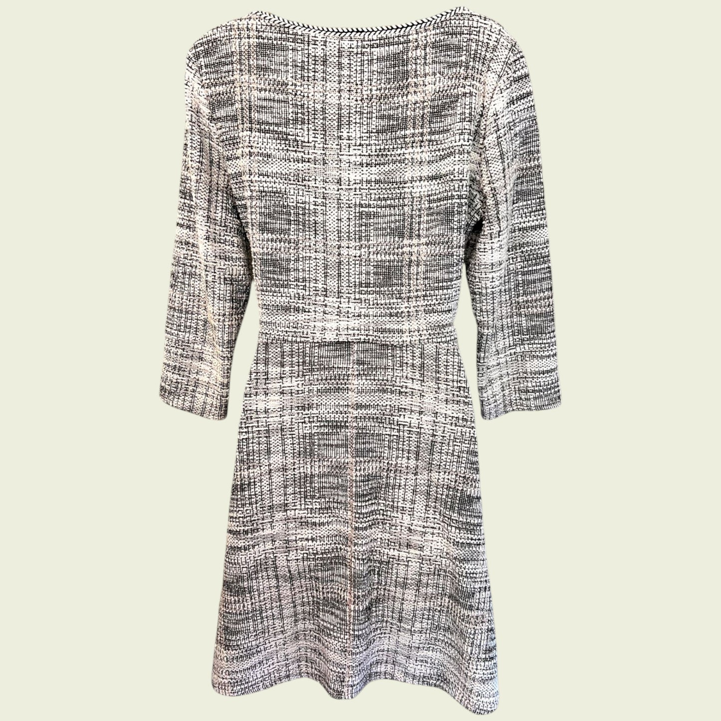 Black and white checkered dress with three-quarter sleeves on a light beige background