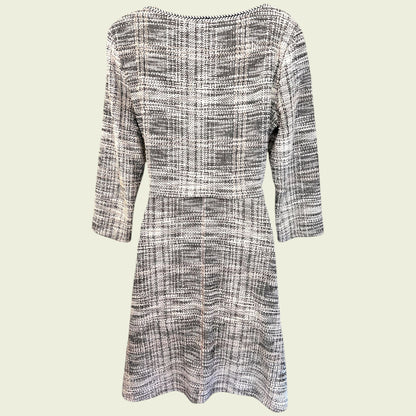Black and white checkered dress with three-quarter sleeves on a light beige background