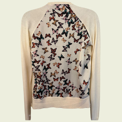 Beige cardigan with butterfly pattern on a light beige background