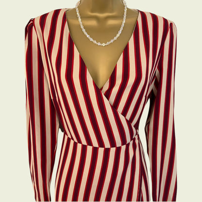 Red and beige striped dress on a mannequin with a plain background