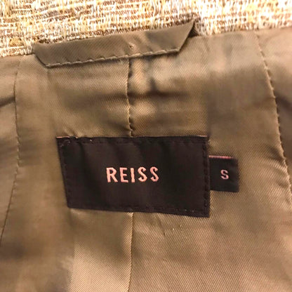 Reiss label on a garment with a beige background