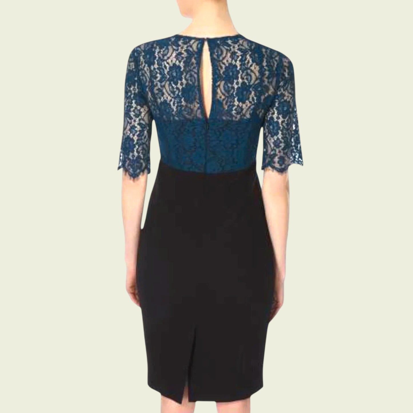 Model wearing black dress with teal lace bolero on beige background