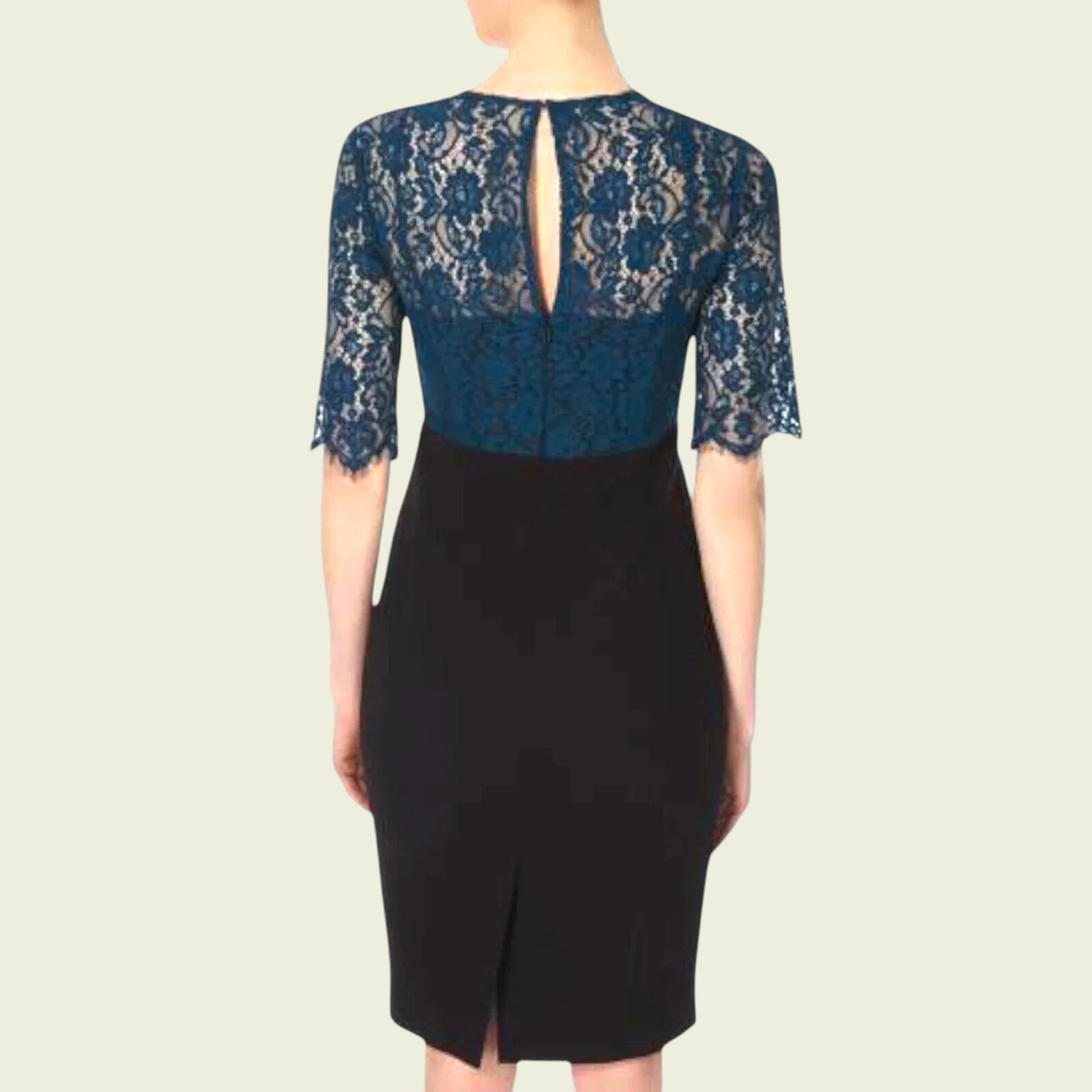 Model wearing black dress with teal lace bolero on beige background