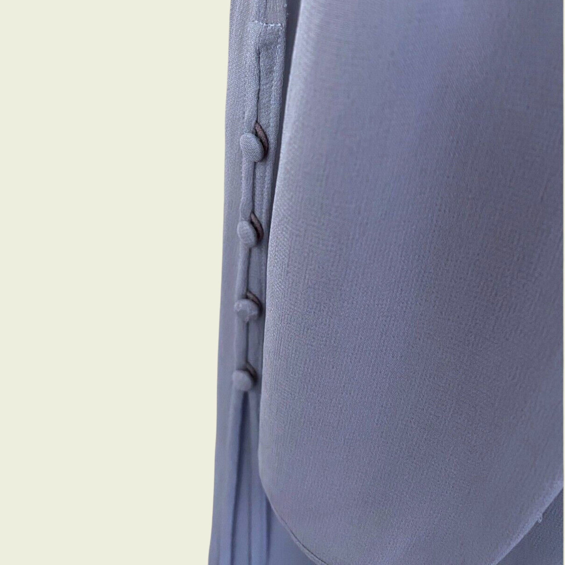Close-up of a textured lilac fabric with stitching detail on a beige background
